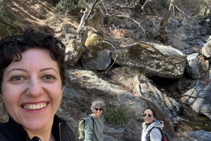 Doğa yürüyüşünde kayalık dere yanında gülümseyen grup