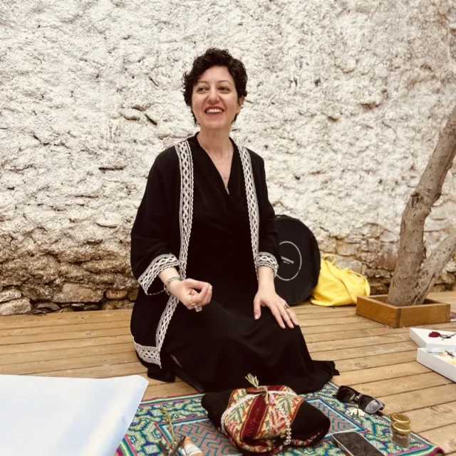 Özbilen Duygu şamanik objeleri önünde içten gülümseyen portre