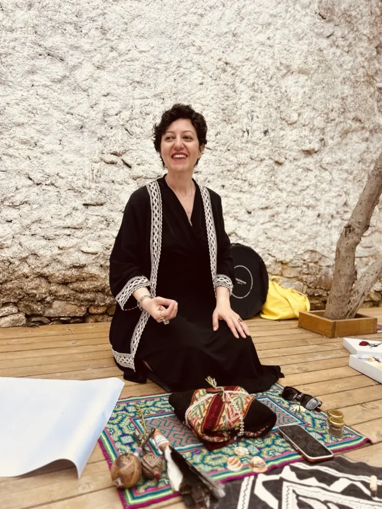 Özbilen Duygu şamanik objeleri önünde içten gülümseyen portre